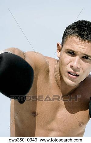 Stock Photo - Portrait of a young man throwing a punch. Fotosearch