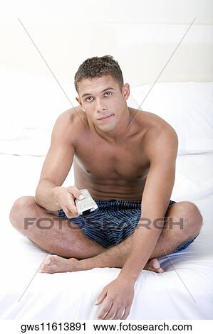 Portrait of a young man using a remote control View Large Photo Image Stock Image - Portrait of a young man using a remote control. Fotosearch