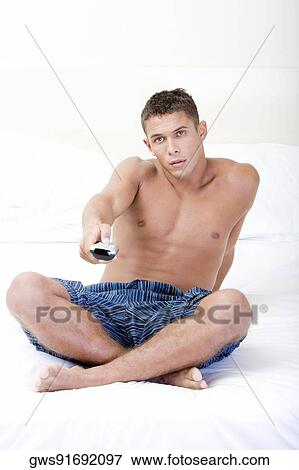 Portrait of a young man using a remote control View Large Photo Image Stock Photo - Portrait of a young man using a remote control. Fotosearch