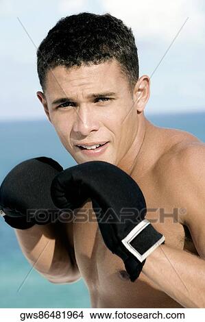 Portrait of a young man wearing boxing gloves View Large Photo Image Picture - Portrait of a young man wearing boxing gloves. Fotosearch