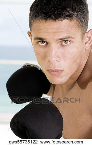 Portrait of a young man wearing boxing gloves View Large Photo Image Stock Image - Portrait of a young man wearing boxing gloves. Fotosearch