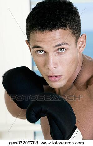 Portrait of a young man wearing boxing gloves View Large Photo Image Stock Photo - Portrait of a young man wearing boxing gloves. Fotosearch