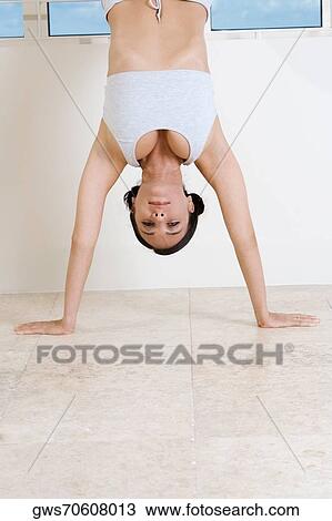Portrait of a young woman doing the handstand View Large Photo Image Stock Image - Portrait of a young woman doing the handstand. Fotosearch