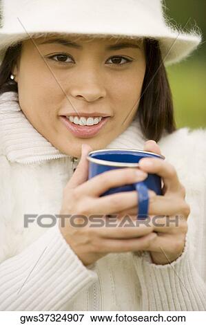 Stock Photo - Portrait of a young woman holding a mug. Fotosearch
