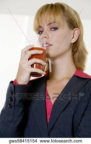 Portrait of a young woman holding a glass of juice View Large Photo Image Picture - Portrait of a young woman holding a glass of juice. Fotosearch