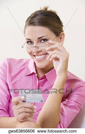Portrait of a young woman holding a credit card View Large Photo Image Stock Photograph - Portrait of a young woman holding a credit card. Fotosearch