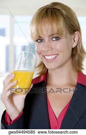 Portrait of a young woman holding a glass of orange juice View Large Photo Image Stock Photography - Portrait of a young woman holding a glass of orange juice. Fotosearch