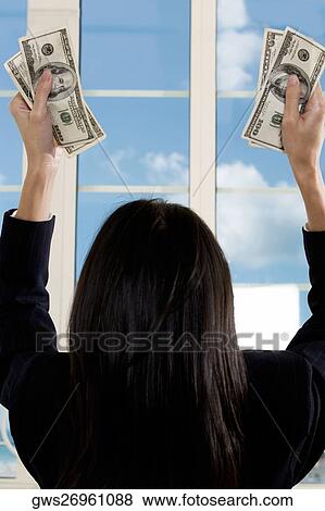Rear view of a businesswoman holding American paper currency View Large Photo Image Stock Photo - Rear view of a businesswoman holding American paper currency. Fotosearch