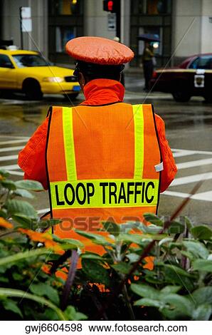 Stock Photo - Rear view of a crossing guard standing in the rain, Chicago, Illinois, USA. Fotosearch