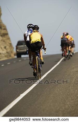 Rear view of a group of people cycling View Large Photo Image Stock Image - Rear view of a group of people cycling. Fotosearch