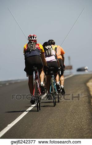 Rear view of a group of people cycling View Large Photo Image Stock Photo - Rear view of a group of people cycling. Fotosearch
