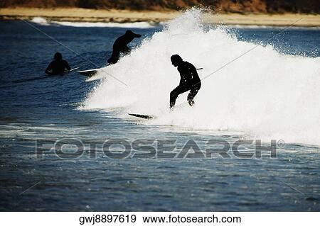 Stock Photo - Rear view of a person surfing. Fotosearch