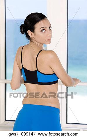 Rear view of a young woman standing near a window View Large Photo Image Stock Photo - Rear view of a young woman standing near a window. Fotosearch