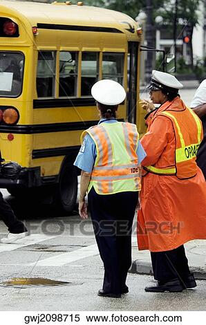 Rear view of two crossing guards standing beside a school bus, Chicago, Illinois, USA View Large Photo Image Stock Photography - Rear view of two crossing guards standing beside a school bus, Chicago, Illinois, USA. Fotosearch