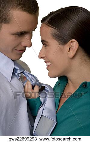 Stock Image - Side profile of a businesswoman holding a businessman by his tie. Fotosearch