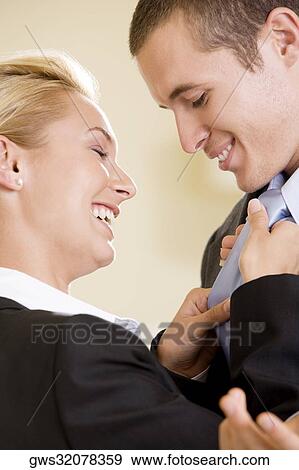 Side profile of a businesswoman adjusting a businessman's tie View Large Photo Image Stock Photo - Side profile of a businesswoman adjusting a businessman's tie. Fotosearch