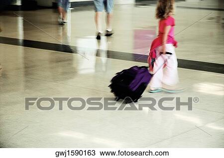 Side profile of a girl pulling a suitcase View Large Photo Image Stock Image - Side profile of a girl pulling a suitcase. Fotosearch