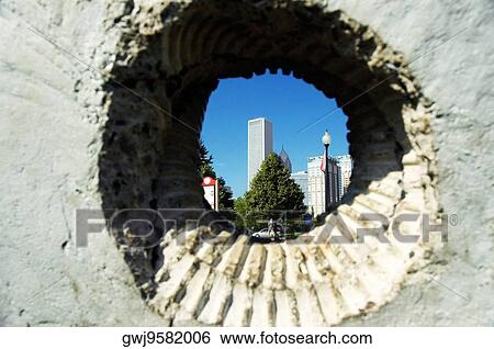 Stock Photograph - Skyscrapers viewed through a hole in a wall, Gateway Park, Chicago, Illinois, USA. Fotosearch
