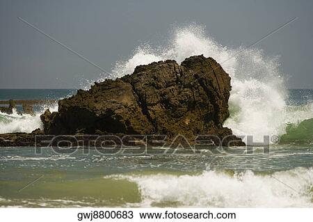 Waves crashing against a rock formation in the sea View Large Photo Image Stock Image - Waves crashing against a rock formation in the sea. Fotosearch
