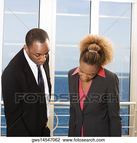 Businessman and a businesswoman looking down in an office View Large Photo Image Stock Image - Businessman and a businesswoman looking down in an office. Fotosearch