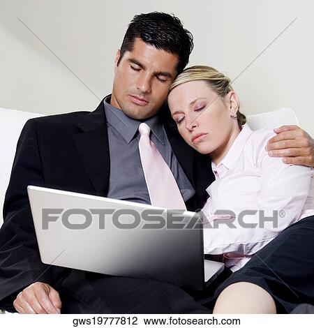Businessman and a businesswoman sleeping in front of a laptop View Large Photo Image Stock Image - Businessman and a businesswoman sleeping in front of a laptop. Fotosearch
