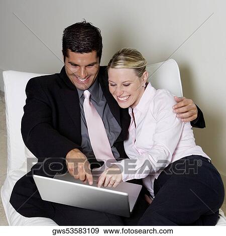 Businessman and a businesswoman using a laptop View Large Photo Image Stock Photo - Businessman and a businesswoman using a laptop. Fotosearch