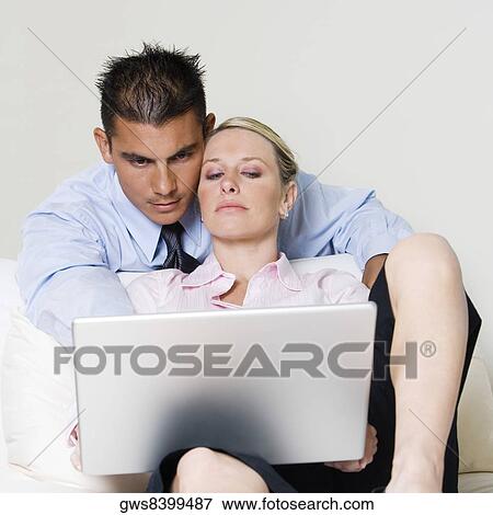 Businessman and a businesswoman using a laptop View Large Photo Image Stock Photo - Businessman and a businesswoman using a laptop. Fotosearch