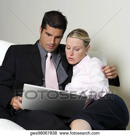 Businessman and a businesswoman using a laptop View Large Photo Image Stock Photo - Businessman and a businesswoman using a laptop. Fotosearch