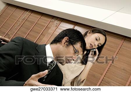 Stock Image - Businessman and businesswoman in an office. Fotosearch