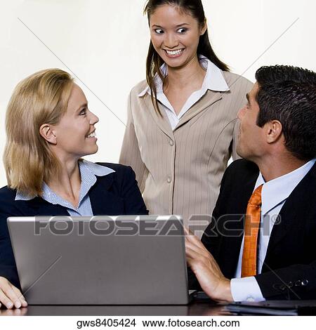 Businessman and two businesswomen in front of a laptop View Large Photo Image Picture - Businessman and two businesswomen in front of a laptop. Fotosearch
