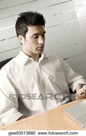 Businessman listening to an MP3 Player View Large Photo Image Stock Image - Businessman listening to an MP3 Player. Fotosearch