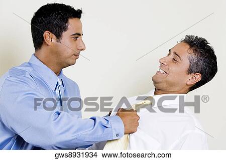 Businessman pulling his Colleague's tie View Large Photo Image Picture - Businessman pulling his Colleague's tie. Fotosearch