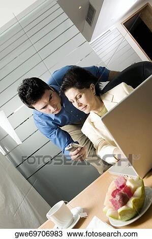 Businessman showing a mobile phone to a businesswoman View Large Photo Image Stock Image - Businessman showing a mobile phone to a businesswoman. Fotosearch