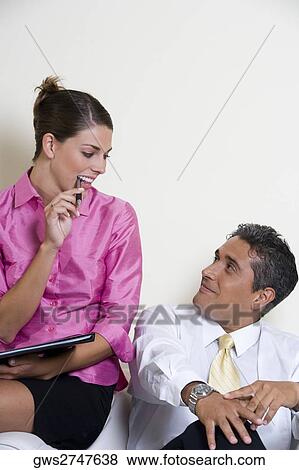 Stock Photo - Businesswoman talking to a businessman. Fotosearch