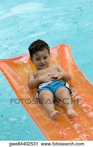 Close-up of a boy floating on a pool raft View Large Photo Image Stock Image - Close-up of a boy floating on a pool raft. Fotosearch