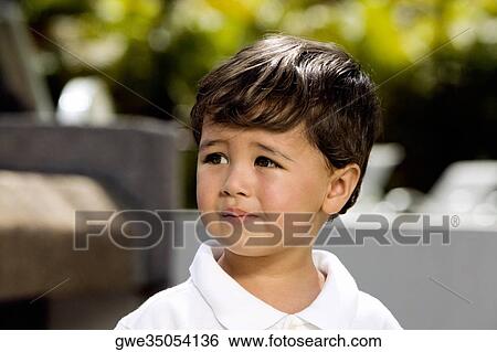 Close-up of a boy looking sad View Large Photo Image Stock Photograph - Close-up of a boy looking sad. Fotosearch