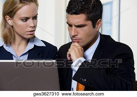 Close-up of a businessman and a businesswoman in front of a laptop View Large Photo Image Stock Image - Close-up of a businessman and a businesswoman in front of a laptop. Fotosearch