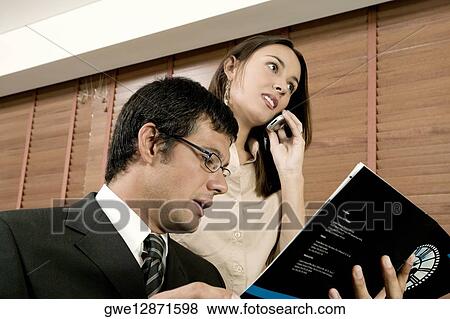 Close-up of a businessman and a businesswoman in an office View Large Photo Image Stock Photo - Close-up of a businessman and a businesswoman in an office. Fotosearch
