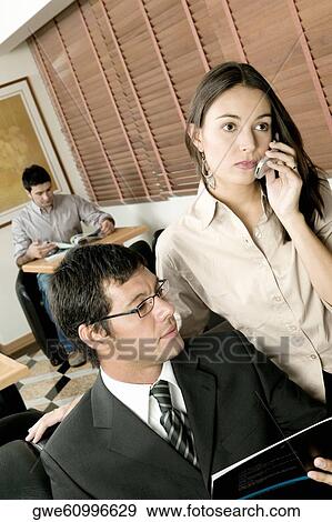 Close-up of a businessman and a businesswoman in an office View Large Photo Image Stock Photo - Close-up of a businessman and a businesswoman in an office. Fotosearch