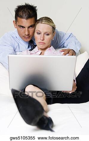 Close-up of a businessman and a businesswoman using a laptop View Large Photo Image Stock Photography - Close-up of a businessman and a businesswoman using a laptop. Fotosearch