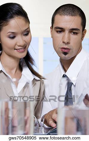 Stock Photography - Close-up of a businessman and a businesswoman discussing. Fotosearch