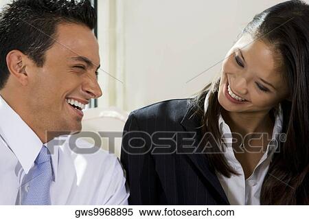 Stock Photography - Close-up of a businessman and a businesswoman smiling. Fotosearch