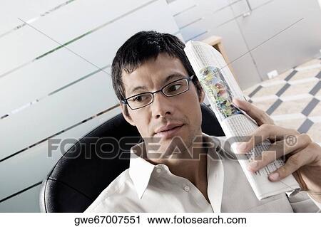 Close-up of a businessman holding a newspaper View Large Photo Image Stock Image - Close-up of a businessman holding a newspaper. Fotosearch