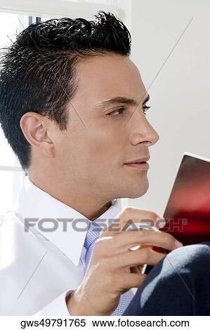Close-up of a businessman holding a magazine View Large Photo Image Stock Photography - Close-up of a businessman holding a magazine. Fotosearch