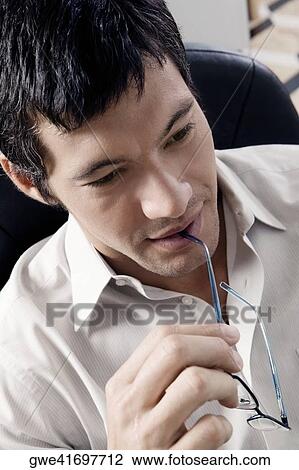 Close-up of a businessman holding eyeglasses View Large Photo Image Stock Image - Close-up of a businessman holding eyeglasses. Fotosearch