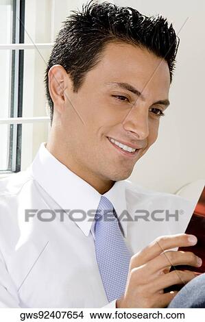Picture - Close-up of a businessman reading a magazine. Fotosearch