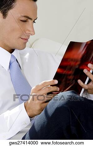 Stock Image - Close-up of a businessman reading a magazine. Fotosearch