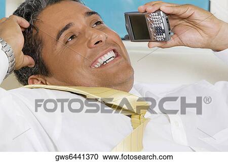 Close-up of a businessman using a mobile phone View Large Photo Image Stock Image - Close-up of a businessman using a mobile phone. Fotosearch