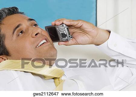 Stock Photo - Close-up of a businessman using a mobile phone. Fotosearch