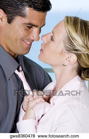 Stock Photo - Close-up of a businesswoman adjusting a businessman's tie. Fotosearch